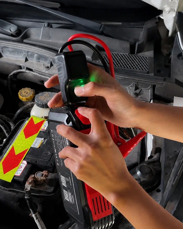 Driver checking a protected battery clamp connection in an engine bay